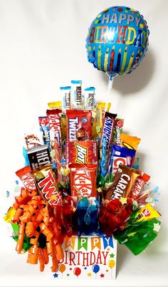 a birthday gift box filled with candy, candies and balloons for someone's birthday