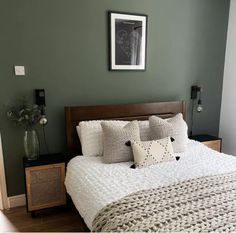 a bedroom with green walls and white bedding