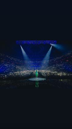 a man standing on top of a stage under spotlights