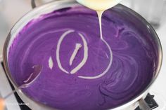 a person pouring batter into a pan on top of a stove with the letter q painted on it