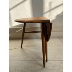 a wooden table sitting on top of a tiled floor next to a window with sunlight coming in