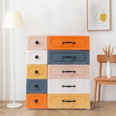 an orange, blue, yellow and white dresser in a room with a wooden chair