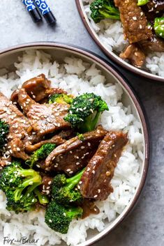 two bowls filled with beef and broccoli on top of white rice