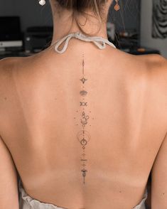 the back of a woman's neck with tattoos on it