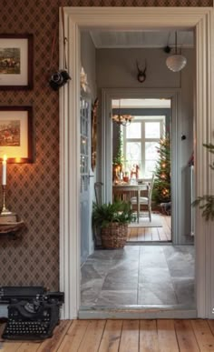 an open door leading to a living room with a typewriter on the floor and potted plants