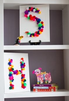 the shelves are decorated with colorful pom - poms and paper letters that spell out the letter s