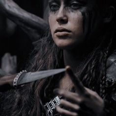 a woman with black makeup holding a knife