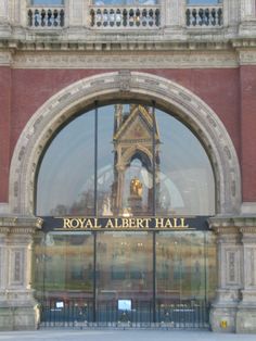 the entrance to royal albert hall in london, england is reflected in its glass doors