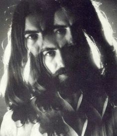 two men with long hair and beards standing next to each other in black and white