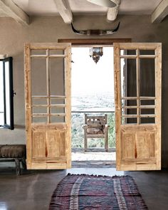 an open door leading to a balcony with a rug on the floor in front of it