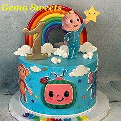 a birthday cake with an image of a cartoon character on top and rainbow in the background