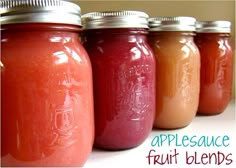 four jars filled with different types of fruit blends on a white counter top next to the words, applesauce fruit blends