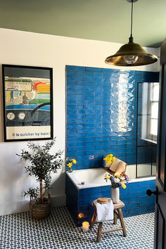 A vibrant bathroom featuring a blue tiled wall, a stylish bathtub a pendant light, creating a refreshing atmosphere. Exposed Bulb Lighting, Ceiling Lights Flush Mount, Vibrant Bathroom, Chandelier Lighting Modern, Rustic Stools, Outdoor Bathroom, Restaurant Lighting