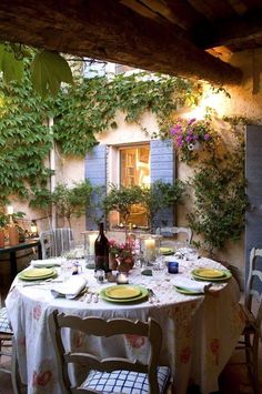 an outdoor dining area with table, chairs and potted plants on the outside wall