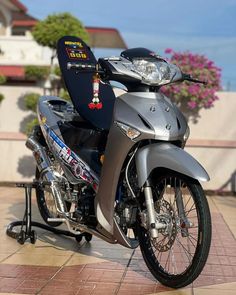 a silver motorcycle parked on top of a sidewalk