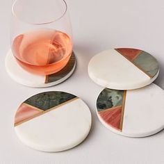 three coasters and a glass of wine on a table