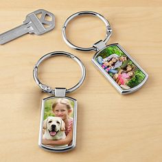 a keychain with two pictures on the front and back of it, sitting next to a pair of keys