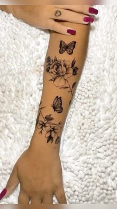 a woman's arm with flowers and butterflies on it