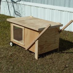 a dog house built into the grass in front of a building