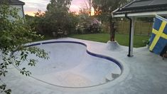 an empty swimming pool in the middle of a backyard with a swedish flag on it