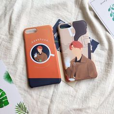 two phone cases sitting on top of a bed next to each other