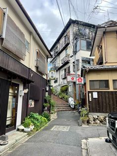 an alley way with several buildings and cars parked on the side walk in front of it