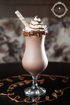 an ice cream sundae with chocolate and whipped cream in a glass on a table