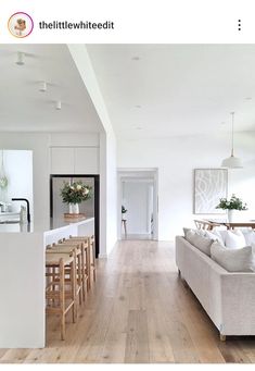 a living room filled with furniture next to a kitchen and dining room table on top of a hard wood floor