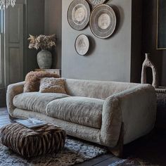 a living room filled with lots of furniture next to a wall covered in plates and vases