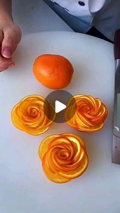 an orange being peeled and cut into spirals on a cutting board with a knife