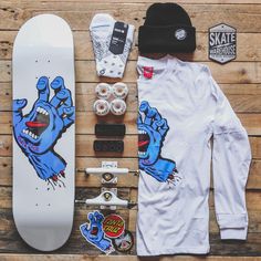 a skateboard, hat and other items laid out on a wooden surface