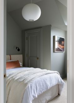 a white bed sitting in a bedroom next to a doorway