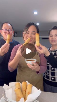 three people holding up food in front of them