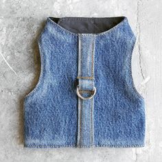 a blue jean vest with a metal ring on it