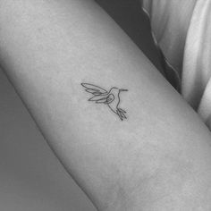 a small hummingbird tattoo on the left inner arm and wrist, it is black and white