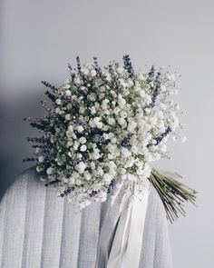 a bouquet of white flowers sitting on top of a chair