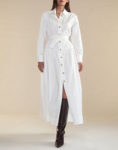 Crisp white cotton shirt dress. Classic collar Gold buttons down front Long sleeves with gold button cuff Maxi length Comfortable, relaxed fit with a cinched waist for a flattering silhouette Complete with a detachable tie belt to accentuate the waist Fabric content: 100% cotton Care instructions: dry clean recommended, machine wash cold, hang dry Fit: model is 5'9" and wears a size S. Size small measurements: Length from shoulder: 48" Shirt Dress White, White Belted Shirt Dress For Work, Elegant Cotton Shirt Dress With Belted Cuffs, Classic White Shirt Dress For Fall, White Shirt Dress With Button Cuffs For Daywear, White V-neck Shirt Dress With Buttons, White A-line Shirt Dress With Buttons, White Shirt Dress With Buttons, Mini Length, White Feminine Button-up Shirt Dress