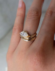 a woman's hand with two rings on it and a diamond in the middle