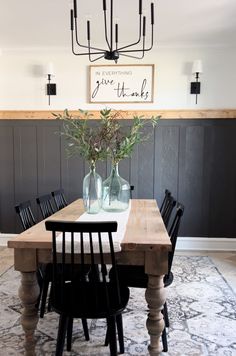 a dining room table with chairs and vases on it