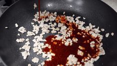 the sauce is being poured into the pan with popcorn kernels in it, and then drizzled on top