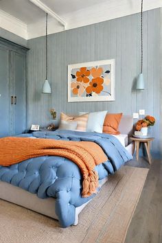 a bedroom with blue walls and orange accents