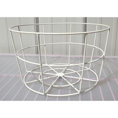 a white wire basket sitting on top of a floor