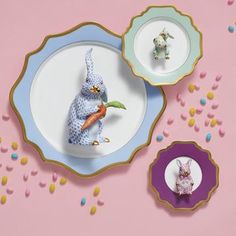 two plates with small figurines on them, one is holding a carrot and the other has a bunny