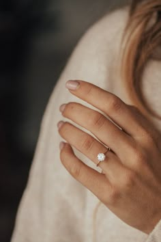 a woman's hand with a diamond ring on it