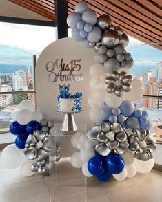 a cake and balloons are on display in front of a window