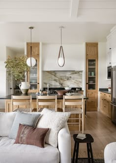 a living room filled with furniture next to a kitchen and dining room table in front of a stove top oven