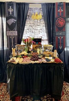 a table topped with lots of food on top of a carpeted floor next to windows