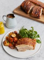 a white plate topped with meat and veggies next to a cup of juice