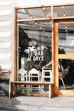 there is a sign in the window that says no bad days and chairs are outside