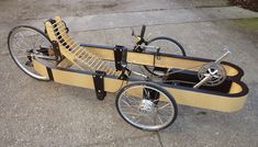 an old style pedal bike is parked on the sidewalk with its wheels still attached to it